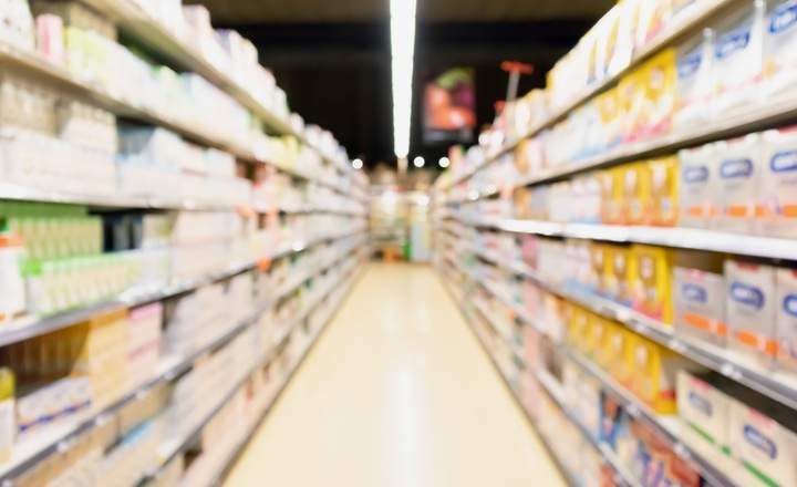 blur supermarket aisle with baby formula milk product on the shelf.