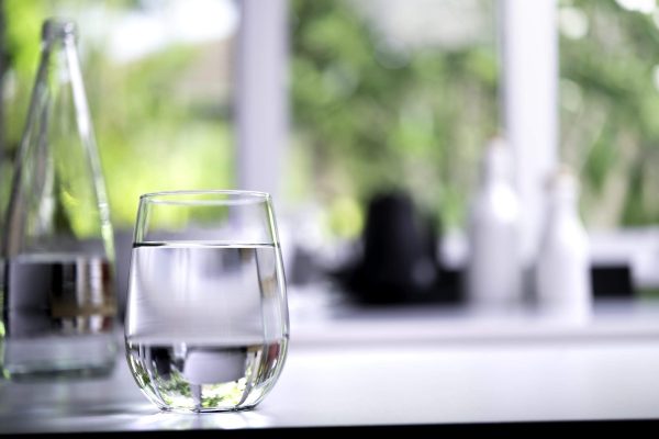 Glass of drinking water on table in kitchen